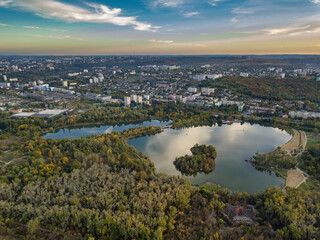 Aerial view of a lake in a park with autumn trees. Kishinev, Moldova. Epic aerial flight over water. Colorful autumn trees in the daytime.