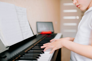 Fototapeta na wymiar Pretty young musician playing classic digital piano at home during online class at home, social distance during quarantine, self-isolation, online education concept