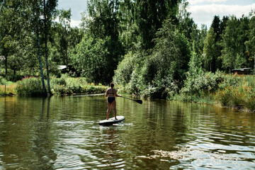 Fototapeta na wymiar Woman on a SUP, stand up paddle