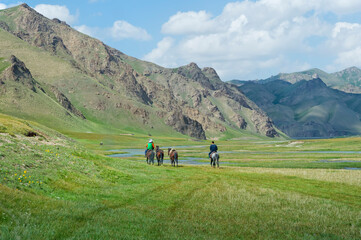 Horsemen riding in Kurumduk valley, Naryn province, Kyrgyzstan, Central Asia