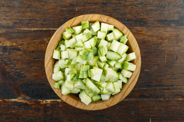 Sliced zucchini in a bowl on a wooden background. Vegetable, ingredient and staple food.