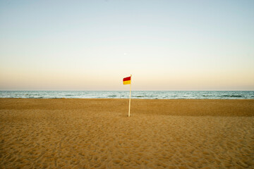Fototapeta na wymiar flag on the beach red and yellow