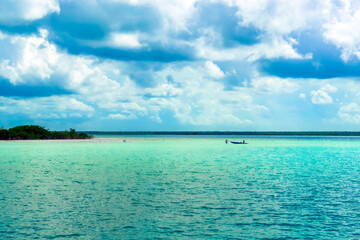 Fototapeta na wymiar A couple with a small boat at Bacalar Lagoon, Quintana Roo / Mexico