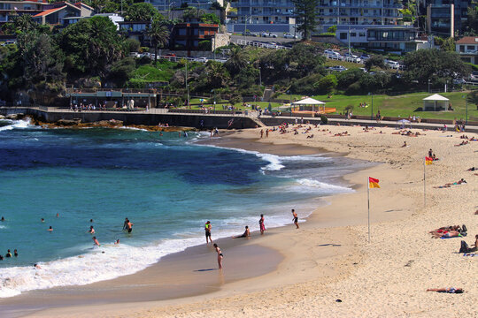 Bronte beach with safety flags and the rock pool in the background
