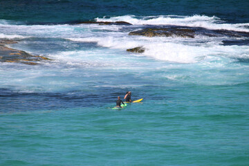 Two surfers on boards waiting to catch a wave. Bronte beach, Sydney