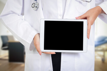 A female doctor holds a tablet in the examination room with a space in the middle for writing a message.