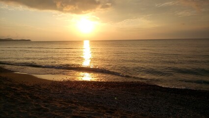 Sunset by the sea view from the beach to the water