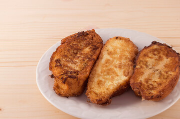 Plate  with three Torrijas Spanish french toast  isolated on white background