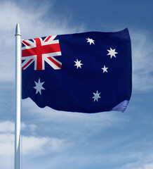 Australian flag on a flag pole with the sky in the background - Australia Day