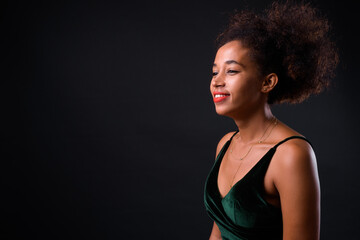 Fototapeta premium Young beautiful African woman with Afro hair against black background
