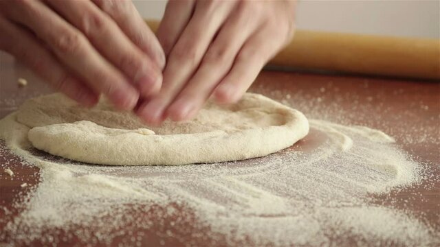 chef hands kneading dough for pizza close up