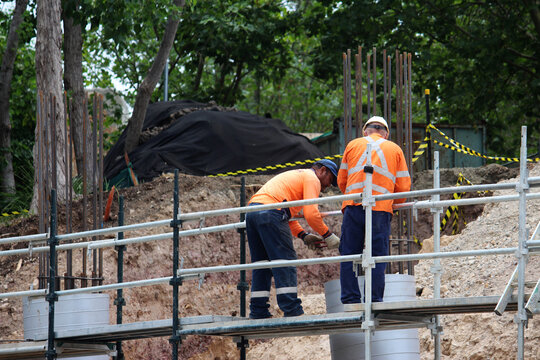 Two men standing on a scaffolding platform working on an Australian construction site