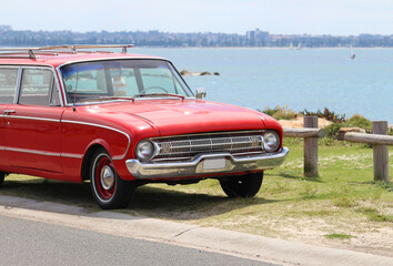 Obraz na płótnie Canvas Vintage red car parked by the beach. Silver beach, Sydney. 