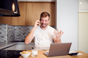 Smiling man working from home with laptop