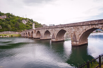 Fototapeta na wymiar Historic bridge over the Drina River, Famous Tourist Attraction, The Mehmed Pasa Sokolovic Bridge in Visegrad, Bosnia and Herzegovina