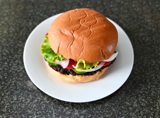fresh burger on a white plate. Gray background. 