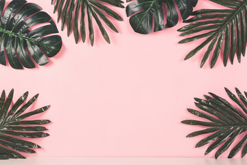 Naklejka premium Tropical background concept. Various palm leaves on pink background. Copy space for your text or product.
