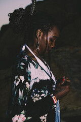 Fototapeta premium A trendy and attractive young black woman in a dress in a shore background in summer. 