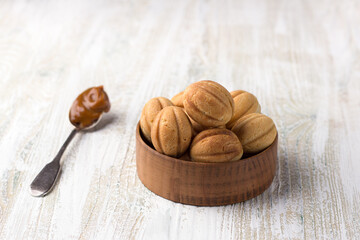 Traditional Russian  shortbread nuts with boiled condensed milk on a wooden background