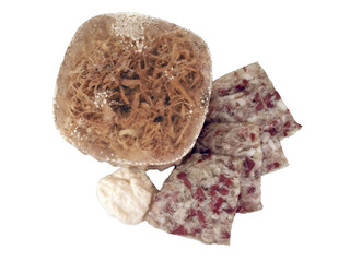 Homemade  Jellied veal, cold cut dish made from veal,  pork, stock, onion and spices, headcheese with slices of pork and beef and grated horseradish on a white background