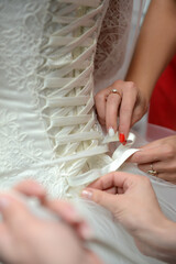 Close-up of a bride corset tightening on a wedding dress.