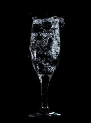 Splashes and drops of water in a glass are isolated on a black .