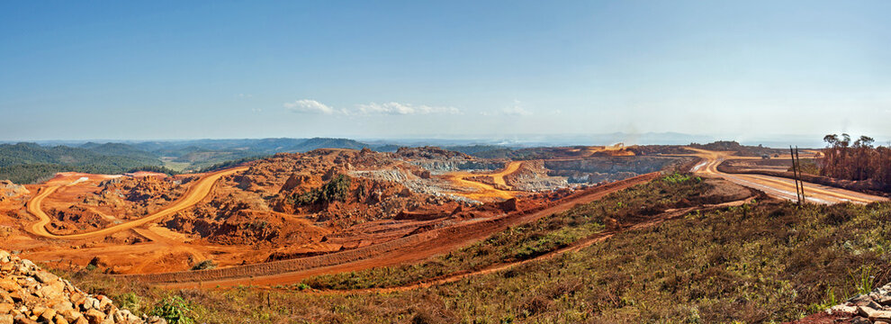 Open pit mine in Africa, with huge crane and trucks ro bring ore to a processing plant 