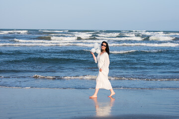 Fototapeta na wymiar Cheerful woman walking on the beach