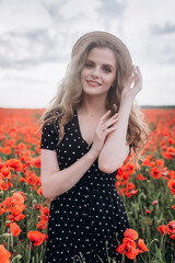 Beautiful woman natural face blondie hair casual female portrait  in red poppy field in hat