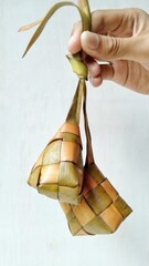 Ketupat, special dish served at Eid Mubarak or Ied Fitr celebration in Indonesia. Ketupat is  is a type of dumpling made from rice packed inside a diamond-shaped container of woven palm leaf pouch.