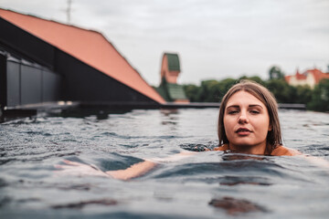The girl swims in the rooftop pool
