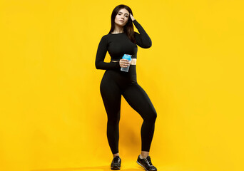 Fototapeta na wymiar Gorgeous body positive Latin woman in a black suit on a yellow background