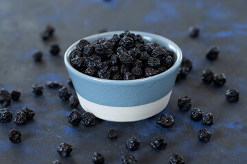 Fototapeta na wymiar raisins in bowl on black background