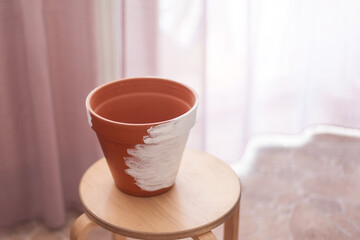 a ceramic flower pot on a wooden chair painted with white paint, unpainted. hobby, gardening, flower transplant