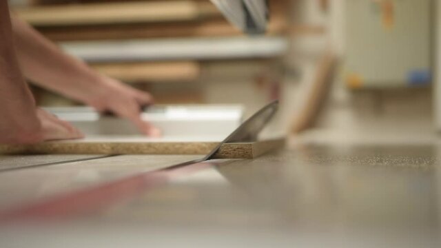 Close up of Machine Cutting wood precisely with a circular saw in 90 degree angle