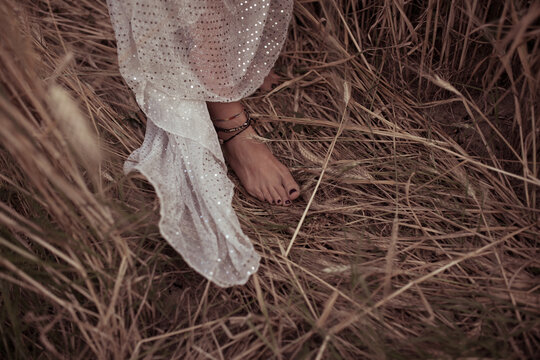 Fotografia dall'alto piedi nudi di donna sul campo di grano. 