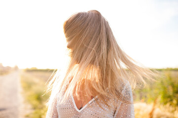 Ragazza avvolta da lunghi capelli biondi. 