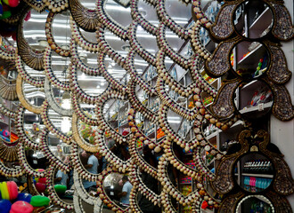 Mirrors for sale in a street market of India. Mirrors designed with shells in South India 