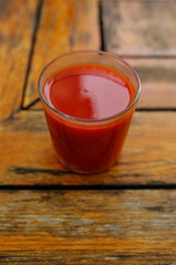 glass of tomato juice on wooden table