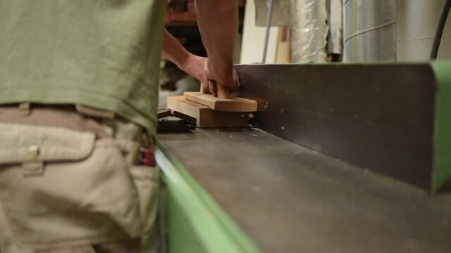 Woodworker planing of board with Chips of wood sawdust flying in the air