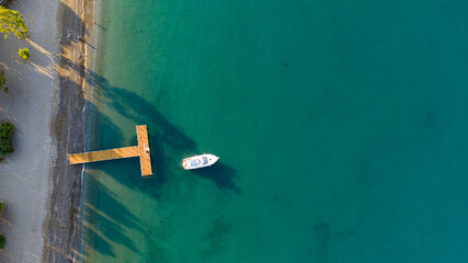 Small boat anchored in the turquoise shores of Aegean sea