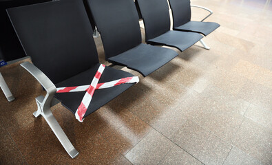 Waiting chairs for passenger before boarding.Seats rewound with warning tape due to coronavirus...
