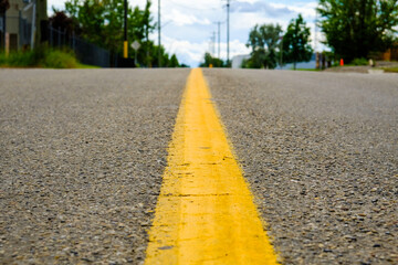 Yellow dividing line on a street in city - Low Angle