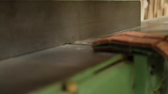 Woodworker planing of board. 