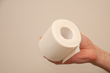 Man's hand holding and giving toilet paper roll.