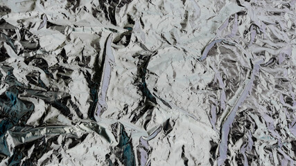 Abstract background. Heart shape in the middle of a crumpled aluminum foil.