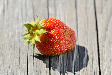 Closeup on fresh and recently picked strawberry placed on wooden board