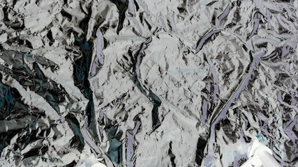 Abstract background. Heart shape in the middle of a crumpled aluminum foil.