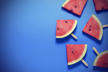 Top view, sliced watermelon fruit on blue table for background.