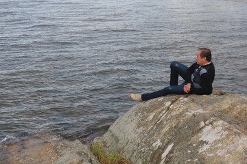 Fototapeta premium man sitting on the rocks